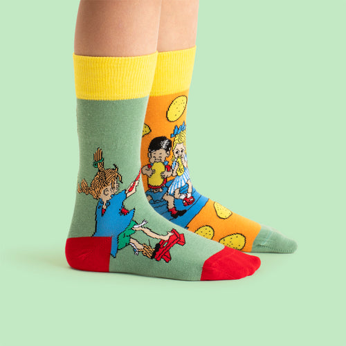 Børnesokker i grønt og orange med motiv af Pippi Langstrømpe, der bager pandekager, fra Svenskhusman.