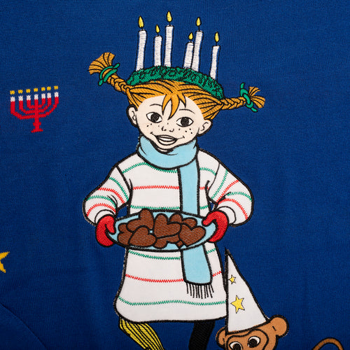Blå stickad jultröja med motiv av Pippi Långstrump som Lucia hållandes pepparkakor från Svenskhusman.