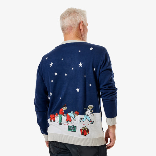 Man bakifrån iförd en mörkblå stickad jultröja med Pippi Långstrump-motiv, stjärnor och julklappar från Svenskhusman.