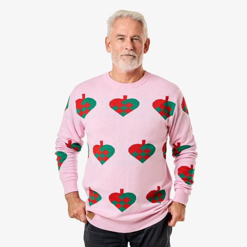 Rosa stickad jultröja med julhjärta-mönster för herr från Svenskhusman på en modell framför vit bakgrund.
