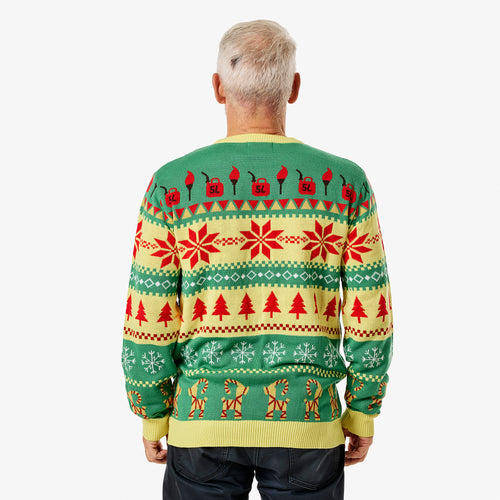 Grön och gul stickad jultröja med Julbocken-motiv, snöflingor och julgranar sedd bakifrån på en modell.