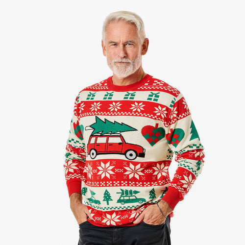 Man i röd och vit stickad jultröja med bil med gran på taket från Svenskhusman.