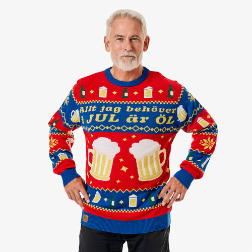 Röd och blå stickad jultröja för herr med julöl-motiv och texten Allt jag behöver i JUL är ÖL på en modell från Svenskhusman.