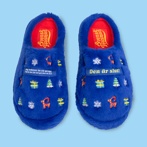 Blå mysiga tofflor med julmönster och textmotivet Jag behöver ta en grogg från Svenskhusman.