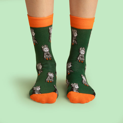 Gröna strumpor med Labolina Halloween-motiv och orangea detaljer på fötter från Svenskhusman.