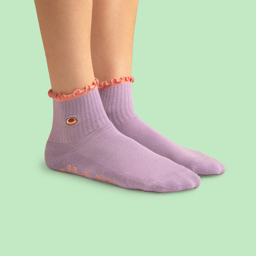 Lila pilatesstrumpor med hallongrottemotiv och rosa volangkant från Svenskhusman.