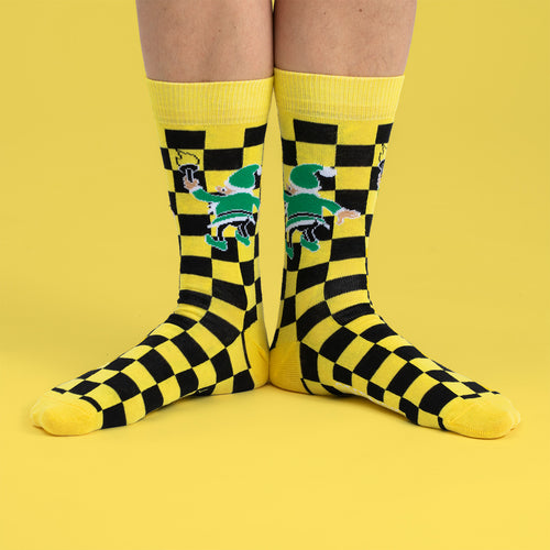 Gul- och svartrutiga strumpor med Tomteverkstad-motiv från Svenskhusman på fötterna.