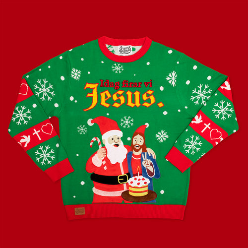 Grön jultröja med texten ”Idag firar vi Jesus”, motiv av tomten och Jesus på röd bakgrund från Svenskhusman.