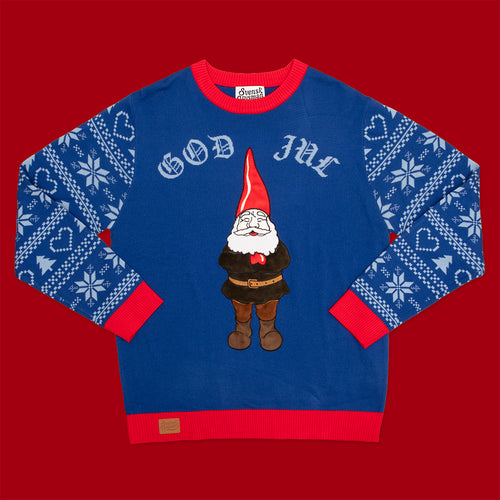 Blå jultröja med hustomte-motiv, texten God Jul och röda detaljer från Svenskhusman på röd bakgrund.