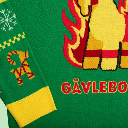 Grön stickad jultröja med motiv av Gävlebocken och flammor från Svenskhusman.