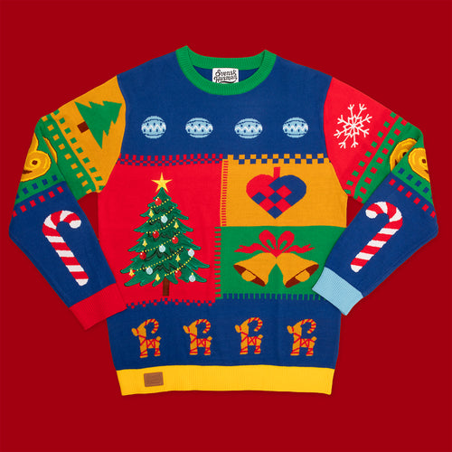 Färgglad stickad jultröja med färgpatch-mönster och olika julmotiv från Svenskhusman på röd bakgrund.