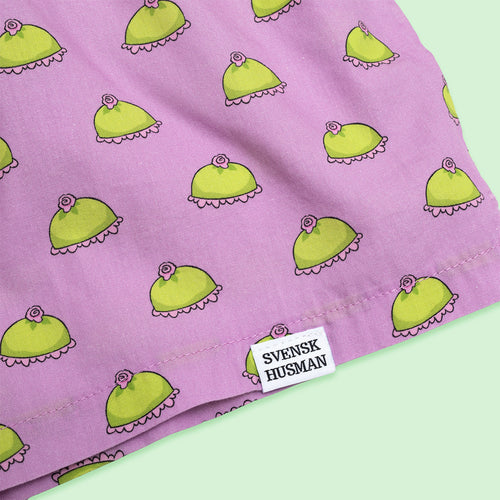 Rosa boxershorts med mönster av gröna prinsesstårtor och en vit Svenskhusman-etikett.