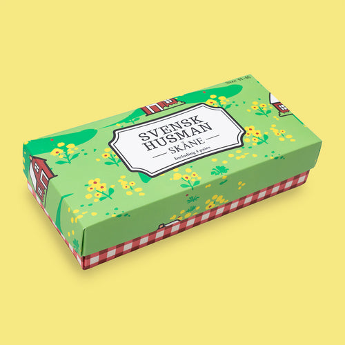 Grön presentbox för Skåne 4-pack strumpor med motiv av röda stugor och rapsfält från Svenskhusman.