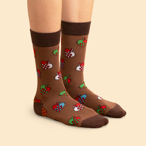 Brauna julSocken med mönster av bunte flätade julhjärtan på fötter från Schwedischhusman.