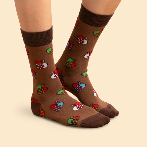 Brauna Socken med mönster av bunte flätade julhjärtan burna på fötter från Schwedischhusman.