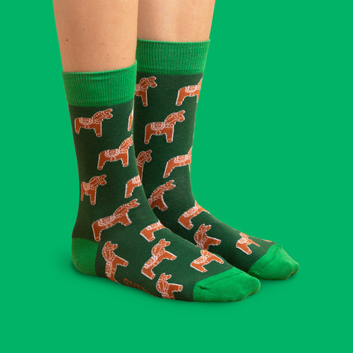 Mörkgrüna Socken med mönster av pepparkaks-dalahästar och ljusgrün tå och häl från Schwedischhusman.
