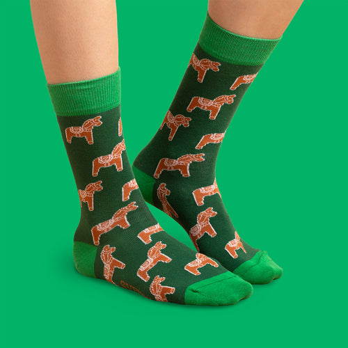 Mörkgrüna Socken med mönster av pepparkaks-dalahästar och ljusgrüna detaljer från Schwedischhusman.