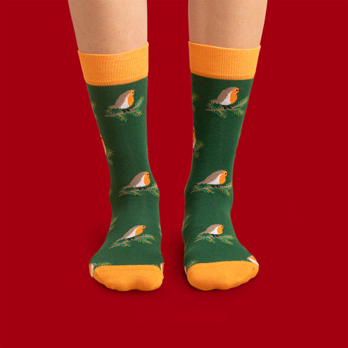 Mörkgrüna julSocken mit Motiv von rothakar på grankvistar och orangea detaljer från Schwedischhusman.
