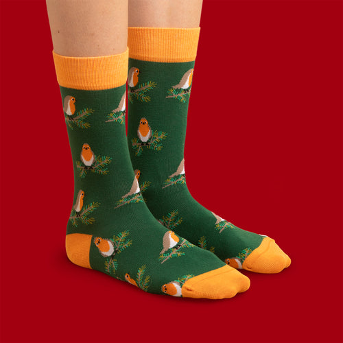 Grüna julSocken med mönster av rothakar på grankvistar och orangea detaljer från Schwedischhusman.
