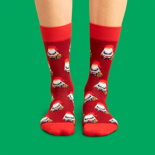 Rota julSocken med mönster av jultomtar och paket från Schwedischhusman mot grün bakgrund.