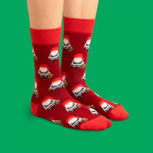 Rota julSocken med mönster av jultomtar och paket från Schwedischhusman mot en grün bakgrund.