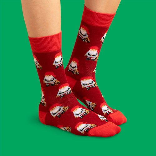 Rota julSocken med mönster av jultomtar från Schwedischhusman mot en klargrün bakgrund.