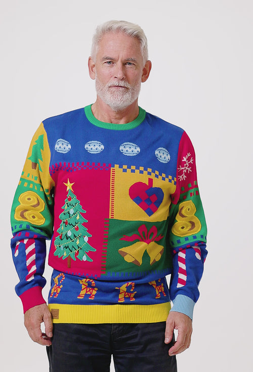 Manlig modell i färgglad färgpatch-jultröja med julgrans- och hjärtmotiv från Svenskhusman.