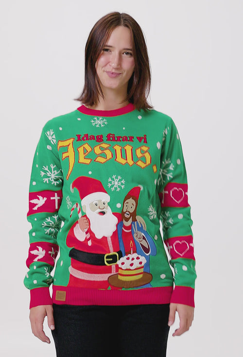 Grön och röd jultröja för dam med motiv av tomte och Jesus, snöflingor samt texten Idag firar vi Jesus från Svenskhusman.